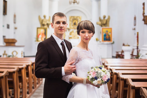新郎和新娘在教堂里穿着白色的礼服。婚礼仪式。幸福的家庭图片下载