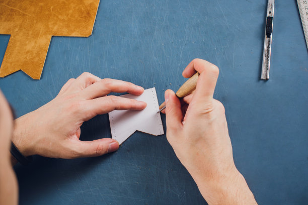 皮革工匠在工作室的桌子上工作，制作产品图片下载