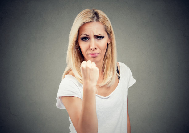 一个愤怒的女人举起拳头的肖像图片下载