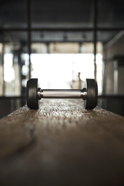 健身房的木桌上放着哑铃，背景是健康人图片下载