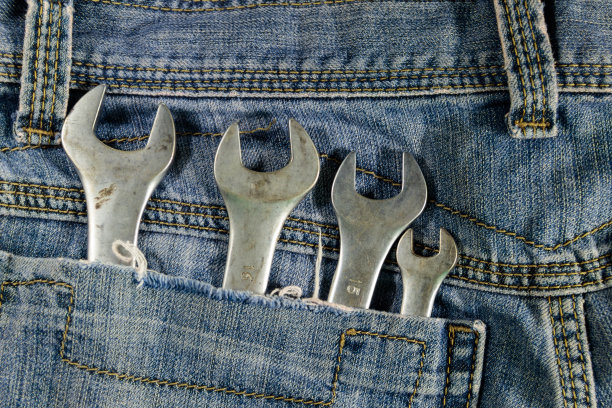 蓝色牛仔裤口袋里的扳手工具图片下载