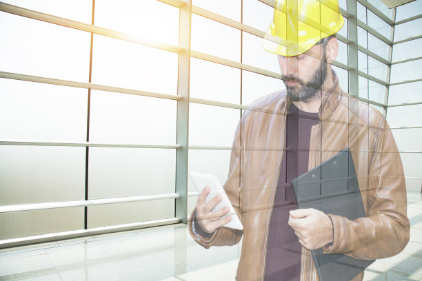 工程师建筑工人操作触控板装置。商业，工程和建筑概念图片下载