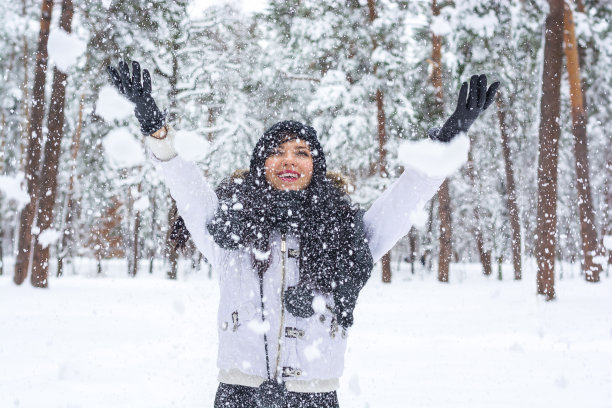 美丽的年轻褐发女人在冬天的森林里玩图片下载
