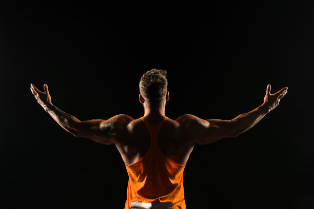 在工作室摆姿势的男性健美者的后视图图片下载