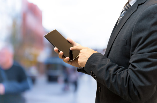 孤立的商人在街上拿着智能手机图片下载