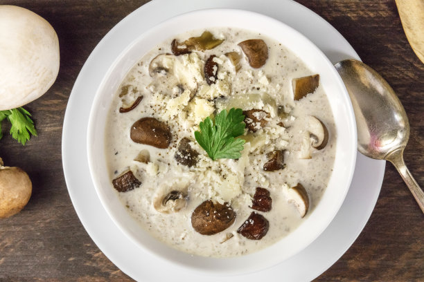 蘑菇汤的特写，配上香槟酒，奶油和欧芹图片下载