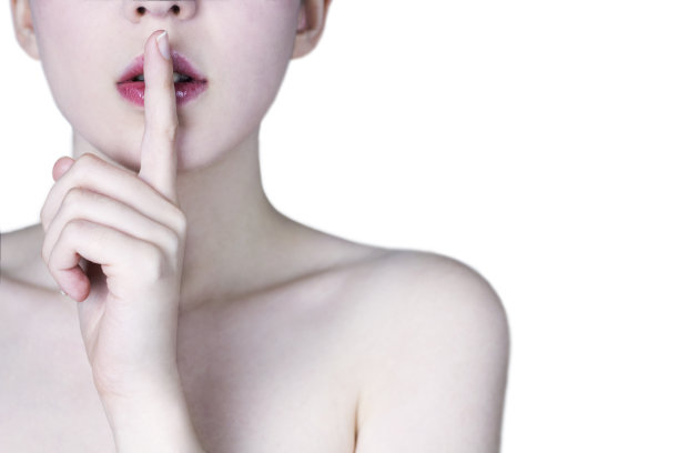 近距离的年轻女子的脸与红色的嘴唇显示沉默的手势在白色的背景-秘密的概念图片下载