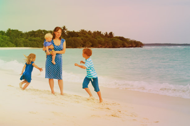 妈妈和孩子们在沙滩上散步玩耍图片下载