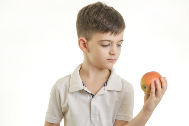 工作室拍摄的小男孩与苹果的健康饮食习惯概念图片下载