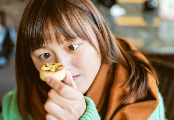 年轻女子正在吃甜点心图片下载