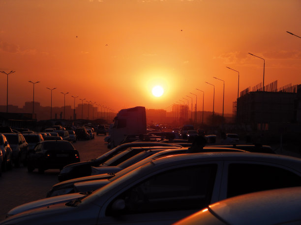 夕阳下汽车的剪影。图片下载