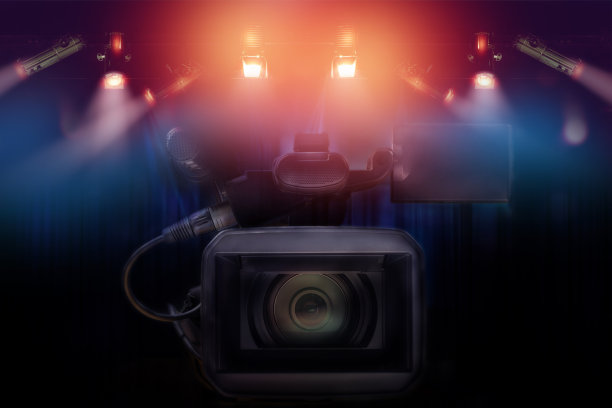 专业摄像机与一套灯悬挂在电视演播室背景。素材图片