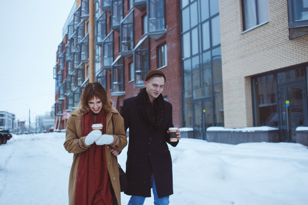 快乐的男人和漂亮的女人走在室外寒冷的冬天的街道上的照片图片下载