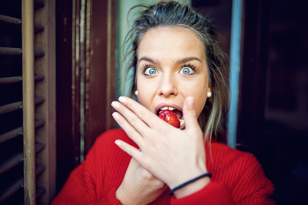 正在节食的小女孩早上躲在阳台上吃草莓蛋糕图片下载