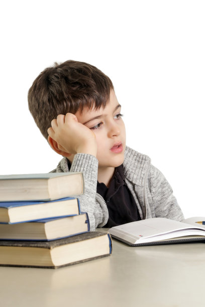 工作室肖像的小男孩努力与他的家庭作业-学习困难的概念图片下载