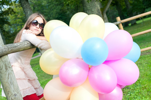 美丽的微笑年轻的少女与彩色气球束图片下载