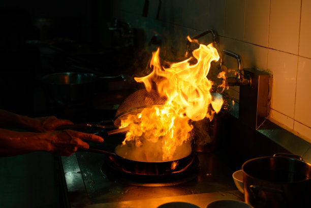 厨师长在餐厅厨房烹饪和做火苗图片下载