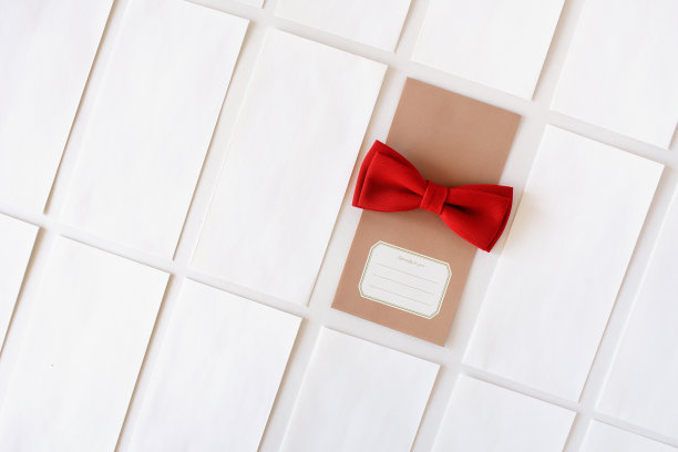 白色背景上有一个红色蝴蝶结的米色礼品信封图片下载