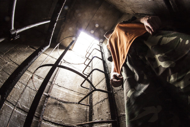 年轻人站在地下房间，仰望光明图片下载