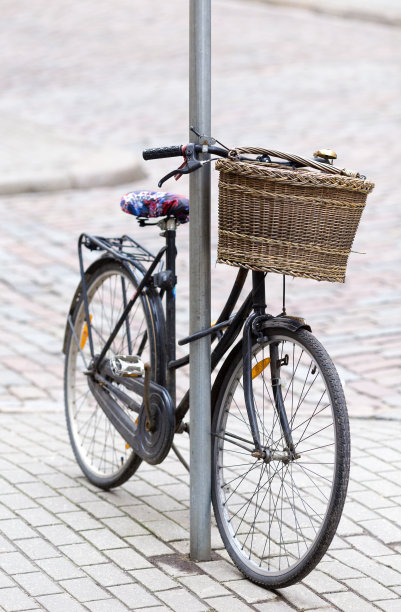 旧的复古自行车与篮子留在设置的人行道在金属杆图片下载