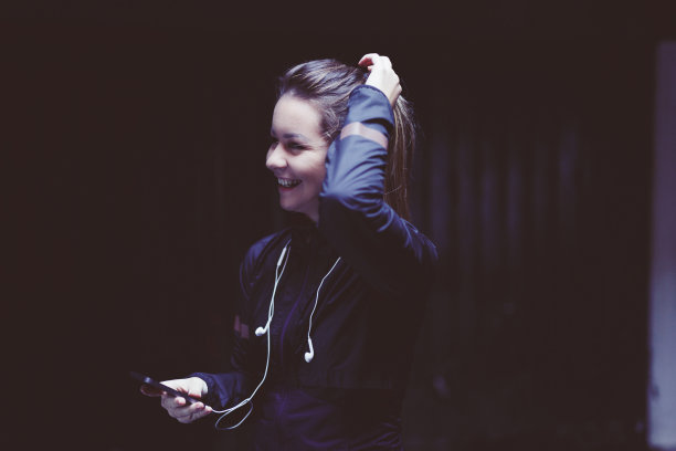 近距离微笑的女孩在运动服装与耳机。图片下载