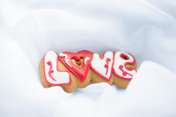 情人节或婚礼的信件饼干在白色轻织物的背景。图片下载
