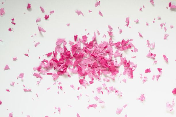白色背景上一堆粉红色的五彩纸屑。庆祝活动的概念。生日，婚礼，情人节。图片下载
