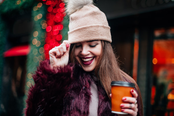 近距离的户外时尚肖像时尚的年轻女子有乐趣，情绪化的脸，笑，低头。城市街道风格图片下载