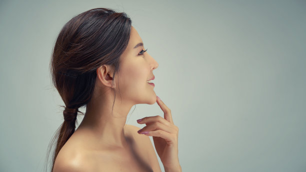 快乐美丽的亚洲女孩与干净新鲜的皮肤触摸脸。富有表现力的面部表情。美容和水疗概念。图片下载