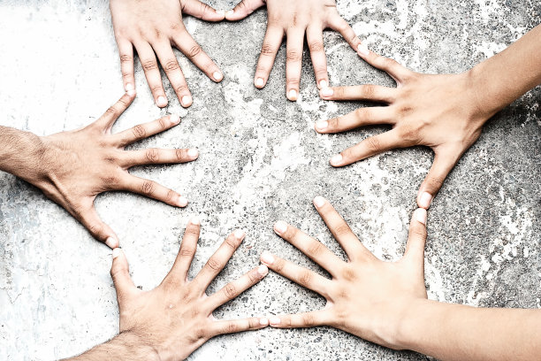 六只手在粗糙的地面上玩游戏。图片下载