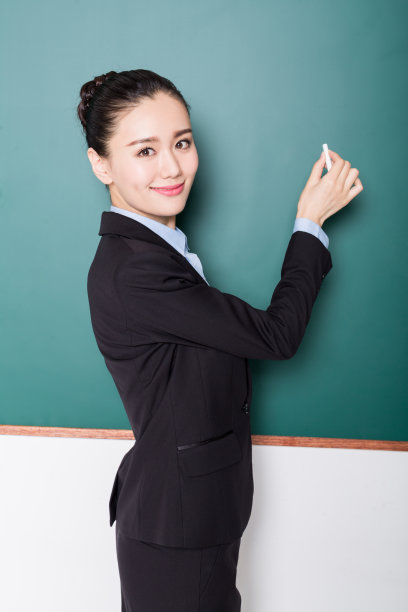 女教师在黑板前手拿粉笔人像素材图片
