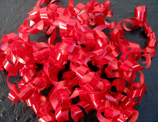 黑色背景上的红色丝带或礼物丝带图片下载