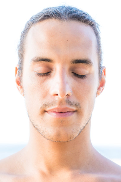 男子的肖像，闭着眼睛，鼻环和头发绑在后面图片下载