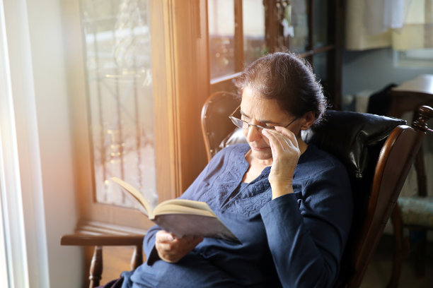 坐在扶手椅上看书的女人图片下载