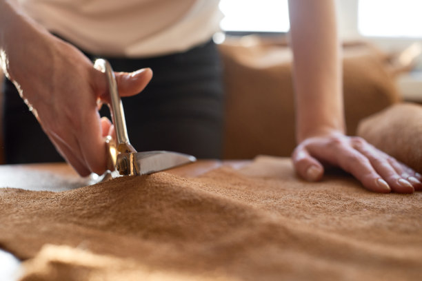 工匠用剪刀切割皮革图片下载