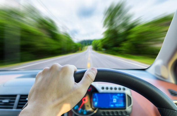 单手握右方向盘行驶在运动道路上图片下载