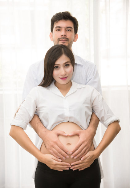 幸福家庭：美丽的孕妇和丈夫充满爱意地拥抱肚子图片下载