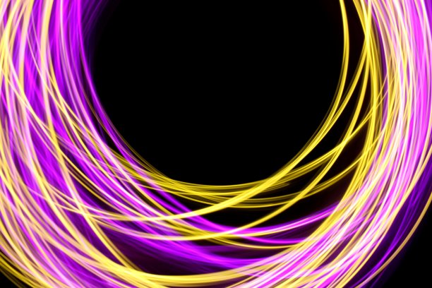 粉色和金色的光画摄影，光线在一个圆圈图案，长曝光照片，以黑色为背景图片下载