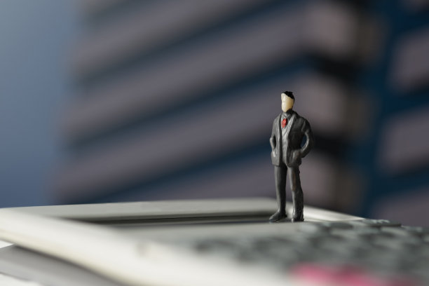 Figure miniature商人或小人站在计算器上为金钱和金融的经营理念。图片下载