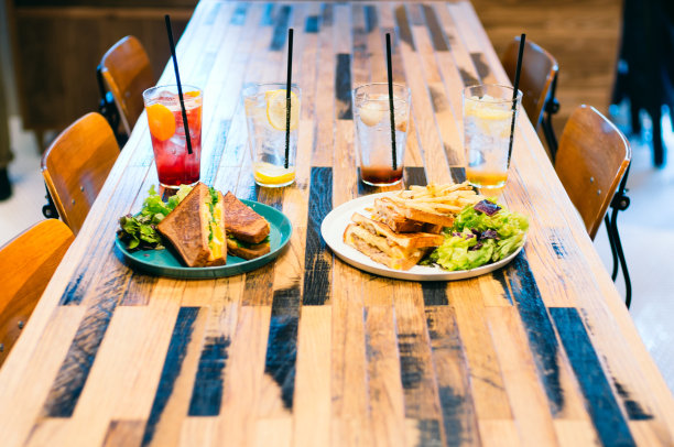 美味的三明治和五颜六色的饮料在咖啡桌上图片下载