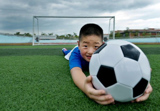 小男孩躺在足球场上图片下载