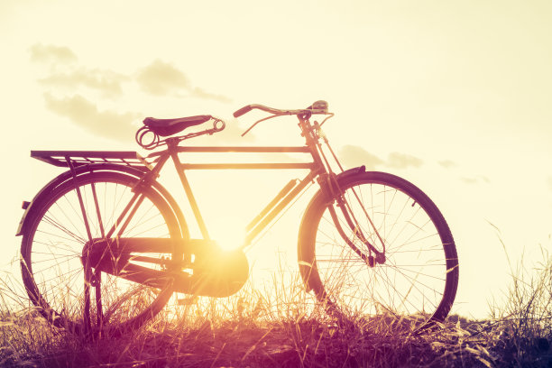 风景图片复古自行车与夏季草地在日落;古董过滤器风格。经典自行车，老式自行车风格的贺卡，明信片图片下载