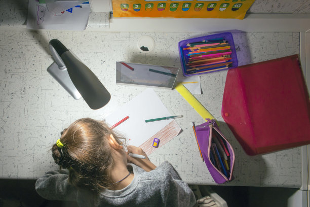 晚上在台灯的灯光下执行学校的课程。图片下载