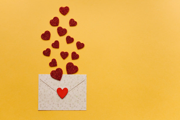 以红心为底、黄色为背景的信封。庆祝。图片下载