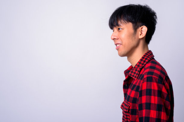 侧面视图的年轻亚洲男子对白种人的背景图片下载