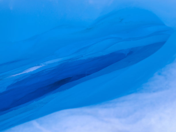 蓝色冰洞背景由雪和光组成图片下载