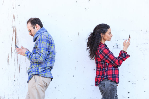 一对欢快的年轻夫妇在街上使用智能手机图片下载