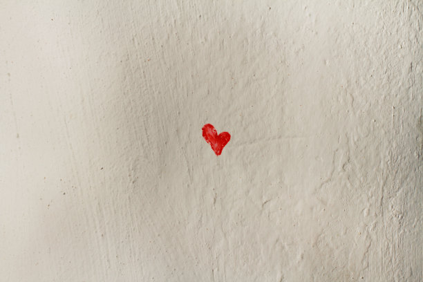 白色粗糙的墙上画着小红心图片下载