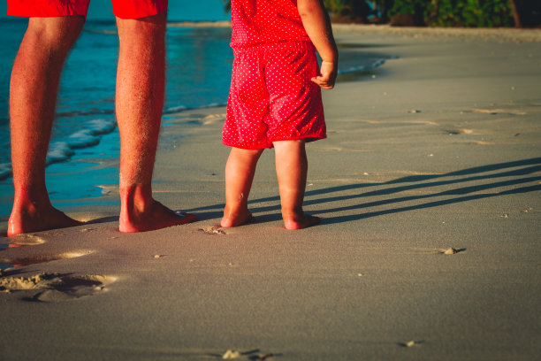 父亲和婴儿在沙滩上散步图片下载