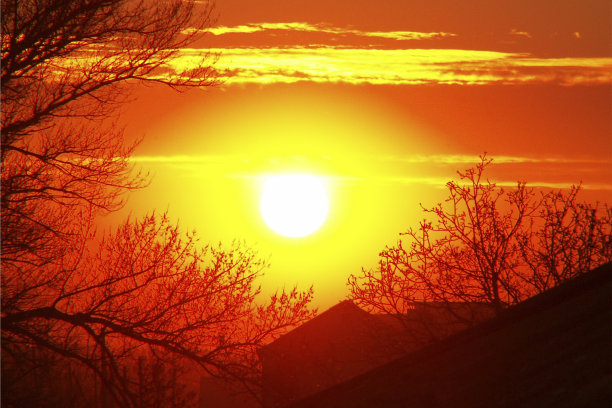 傍晚的景色，大太阳在房子上面。照片的一个明亮美丽的日落。图片下载